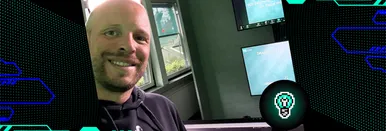 Nils Binder lächelt in die Kamera während einer Lehrveranstaltung an der FOM Hochschule; im Hintergrund sind Präsentationsfolien zum Thema Web-Technologien für den Studiengang UX Design & Digital Solutions zu sehen.