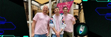 Das dreiköpfige 9elements Team lächelt gemeinsam in die Kamera, im Hintergrund ist die Flagge des CSS Café 2025 zu sehen.