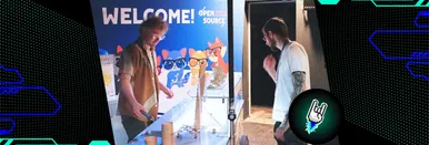 Foto vom Eingangsbereich der OSFC 2024. Zwei Männer, die vor dem Banner mit "Welcome Open Source 2024" stehen und die Theke anschauen.